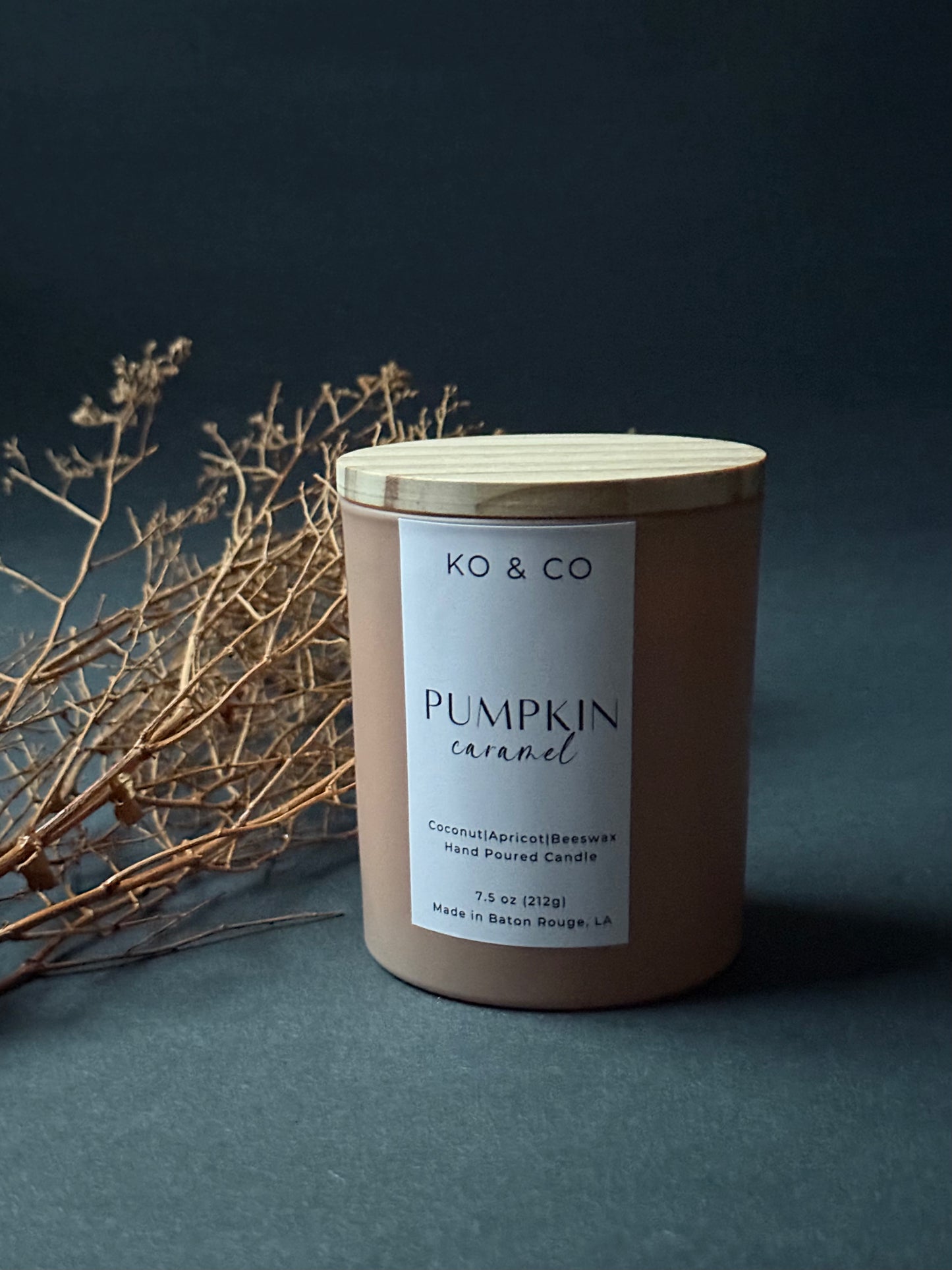 KO & CO pumpkin caramel candle with wooden lid on a dark background