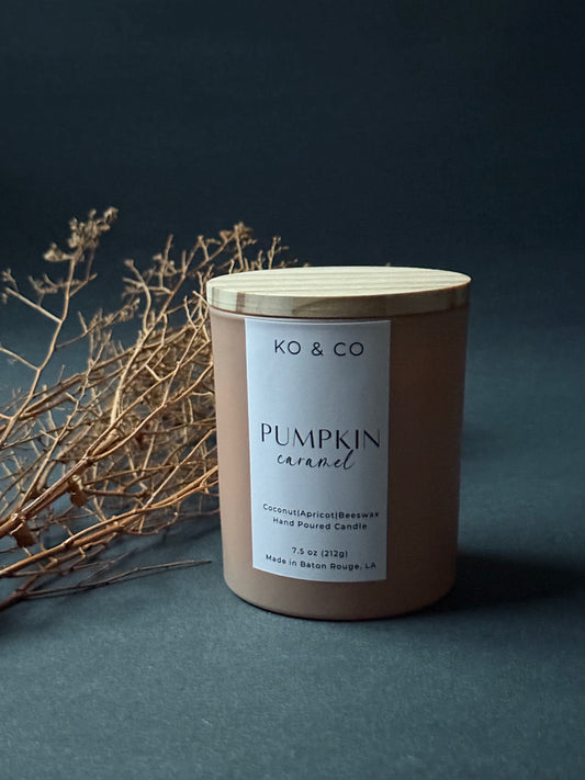 KO & CO pumpkin caramel candle with wooden lid on a dark background