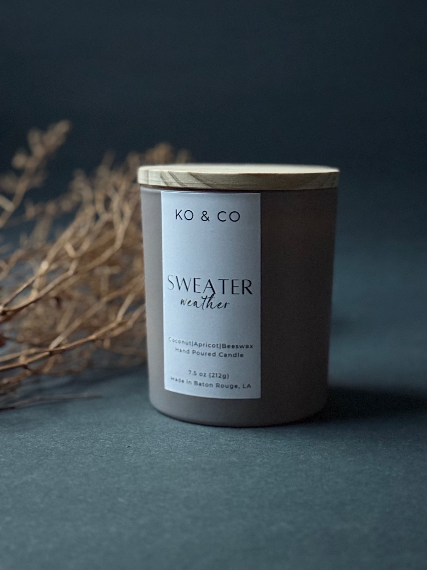 KO & CO candle labeled 'Sweater Weather' on a dark background